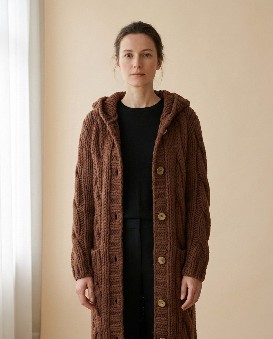 Gilet long à capuche en grosse maille torsadée, porté par un mannequin